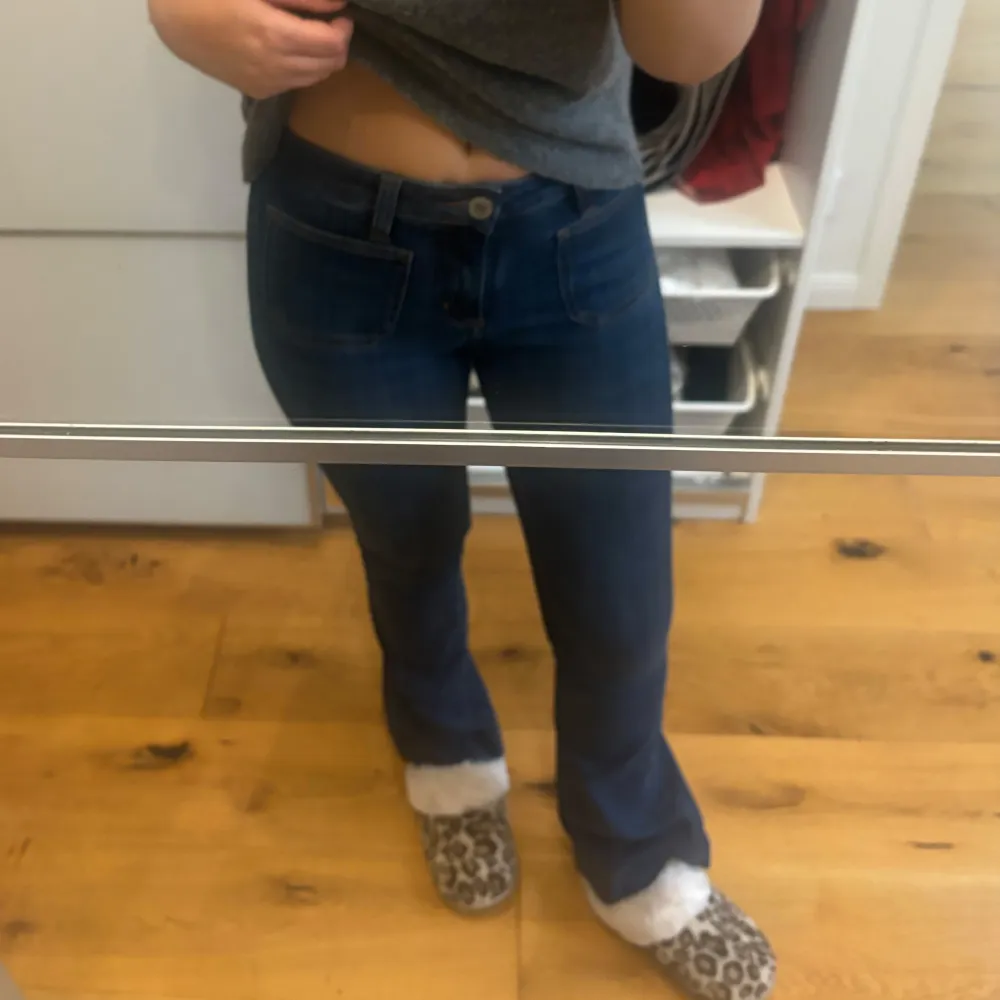 Säljer ett par snygga mörkblå jeans i bra skick. De har en klassisk design med en knapp och fickor framtill. Perfekta för vardagsbruk och kan enkelt matchas med olika toppar. Passar bra till både sneakers och boots.. Jeans & Byxor.