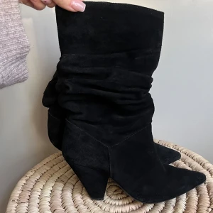 Svarta mockastövletter med spetsig tå - Snygga svarta stövletter i mocka med en spetsig tå och klack. Perfekta för hela året både sommar och vintern. Säljer för att de inte passar, nypris 1070kr (399.99 PLN)