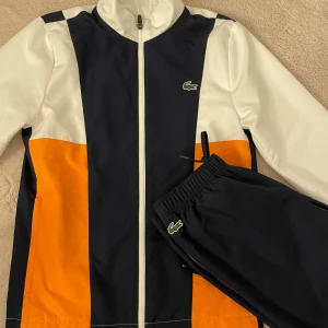 Set ifrån Lacoste  - Jacka och byx set ifrån Lacoste i storlek XS. Köpt i Lacoste butik i Sverige. Använd två gånger, ny skick. 