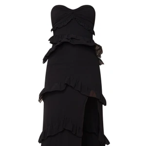 Svart festklänning - Svart festklänning med volanger och slits, klänningen har använts vid ett tillfälle i ett fåtal timmar och är i nyskick. Nypris är ungefär 450kr.