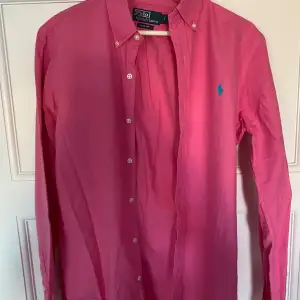 Säljer en snygg rosa skjorta från Polo Ralph Lauren i slim fit. Skjortan har långa ärmar och knappar fram. Perfekt för både vardag och fest! 💖