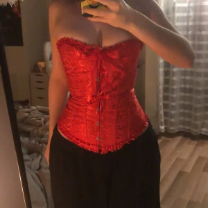 Korsett - Säljer min helt oanvända röda korsett:) skulle haft vid halloween men den hann inte komma tyvärr, så har ingen användning för den😊 den är lätt att dra åt och sitter fint:) köparen står för frakten!