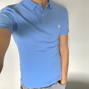 Ralph Lauren piké - Säljer denna riktigt schyssa ljusblåa piké från Ralph Lauren. Det är en custom design och nypris ligger på ca 1500. Den är i väldigt bra skick! Den är i storlek S och jag är 180. Vid eventuella frågor eller funderingar är det bara att höra av sig!