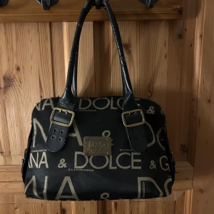 Dolce & Gabbana väska - 🤎!!FRÅGA OM FLER BILDER!!🤎         Super snygg väska från Dolce and Gabbana!Skicket är inte alls bra och handtaget flagnar när man håller i väskan!Vet inte om väskan är äkta heller då jag inte har några bevis.(köpte second hand).Kan knappast säga att skicket är tillfredställande då den flagnar jätte mycket är i ett mycket dåligt skick!Jag själv har bara använt väskan som prydnad då man inte kan hålla den utan att den flagnar!👜🤎Fråga om fler bilder då det är mycket dåligt skick!!!