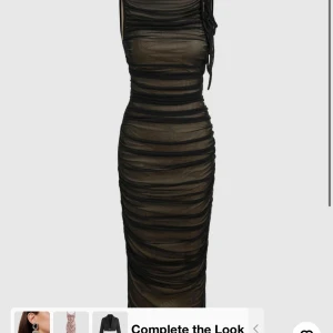 Svart tight klänning - Snygg svart tight klänning med ett transparent lager som ger en cool effekt. Perfekt för fest eller en utekväll. Klänningen är ärmlös och har en smickrande passform som framhäver figuren. Materialet känns bekvämt och stretchigt.