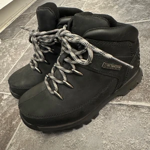 Svarta kängor från Timberland (barn) - Säljer ett par svarta kängor från Timberland i mycket bra skick. De har robust snörning och är perfekta för höst- och vinterväder. Perfekta för utomhusaktiviteter! Storlek 31