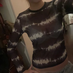 Tiedye genomskinlig tröja mörkblå  - Jätte fin genomskinlig tiedye tröja, är i lite silkigt runt material men är väldigt bekväm och bära. Funksr super bra som fest topp men även casual. Storlek S. Ser svart och vit ut men är mörkblp