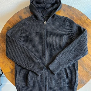 Mörkblå stickad hoodie med dragkedja, storlek M/S - Säljer en svart stickad hoodie i mycket bra skick. Funkar för både M och S, hör av dig vid frågor !