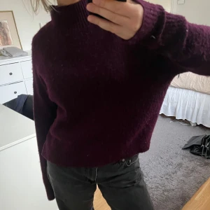 Mysig lila stickad tröja - Säljer en supermysig lila stickad tröja i mycket bra skick. Perfekt för höst och vinter med sin varma och sköna känsla. Tröjan har långa ärmar och en ribbad kant vid halsen. Passar perfekt till jeans för en avslappnad look.