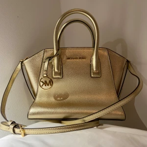 Michael Kors - Säljer min fina michael kors väska i guld. Köpte för två månader sedan och den är helt ny och oanvänd💗