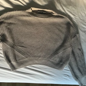 Hårdstickad grå tröja  - En hårdstickad croppad grå tröja från NaKd i storlek xs, den är overzised i modellen (jag är vanligtvis en storlek M). Jättefin i materialet och sitter jättefint, speciellt med balongärmarna. Har bara aldrig använt den:) 