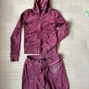 Juicy set - Juicy set i vinröd! Tyget har tecken på att vara använd. Jag har sytt upp byxorna, se sista bilden. Innerbenslängd: 78cm