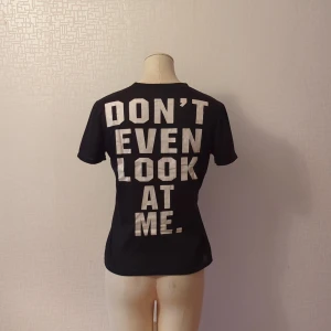 Rolig t-shirt - En rolig t-shirt med tryck på ryggen. Tröjan är i använt skick och är litte nopprig i tyget men inga sprickor eller lossnigar i trycket. Den är något genomskinlig.