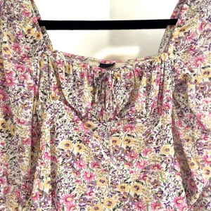 Blommig topp långärmad  - Säljer en superfin blommig topp med långa ärmar. Toppen har en smickrande passform och knyt vid bysten. Ny utan prislapp!💕🌸