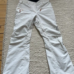 Skidbyxor från Wear Color - Vita skidbyxor från Wear Color i storlek S. Tyvärr blivit fläckar, oklart om dom går bort. Är några mörka fläckar nere i byxbenen också. Kan skicka bild på det. 