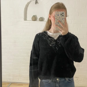 Stickad tröja med spets - Svart stickad tröja med fin spetsdetalj. Storlek 36 i fint skick.