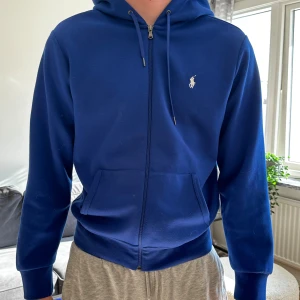 Ralph Lauren Hoodie - Blå huvtröja från Ralph Lauren, väldigt snygg och ögonfångande färg! Skicket är som ny. Köpt för 2195kr.