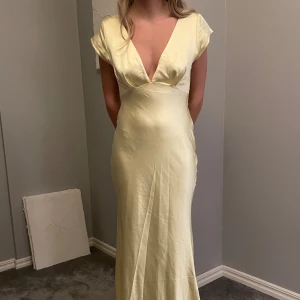 Långklänning  - En långklänning i fin pastellgul färg, endast använd 1 gång på balen. Köpt för 1800 kr. Är 163 cm lång och går ner till fötterna på mig 