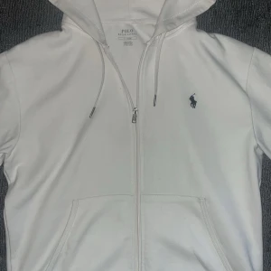 Vit hoodie från Polo Ralph Lauren - Säljer en vit hoodie från Polo Ralph. Perfekt för en avslappnad stil och passar till alla tillfällen.och i bra skick! om de nåt ni undrar över skriv bara i DM!