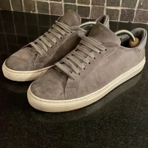 Grå mocka sneakers - Säljer ett par snygga grå sneakers i mocka från Axel Arigato. De är sjukt feta och perfekta för både vardag och lite mer uppklädda tillfällen. Skorna är  redo för nya äventyr! 