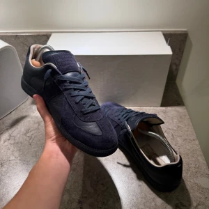 Maison Margiela Gats  - Ett par riktigt snygga mörkblåa Maison Margielas för bara 3499kr och nypris ligger på 5999kr. Dustbag och låda finns. En liten defekt finns, men inget som syns. Pris är förhandlingsbart, och vid mer frågor är de bara att skriva. 