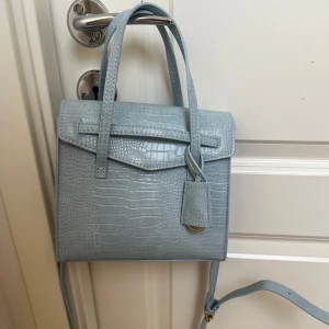 Väska  - Väska med justerbart band ifrån Lindex aldrig använd 