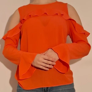 Korallfärgad blus med bara axlar och volag - Corallfärgad blus med bara axlar och volang över bröstet.  Tröjan framstår slm väldigt mycjet mer orange på bilderna än vad den är i verkligheten.  (Sista bilden visar tröjans material)