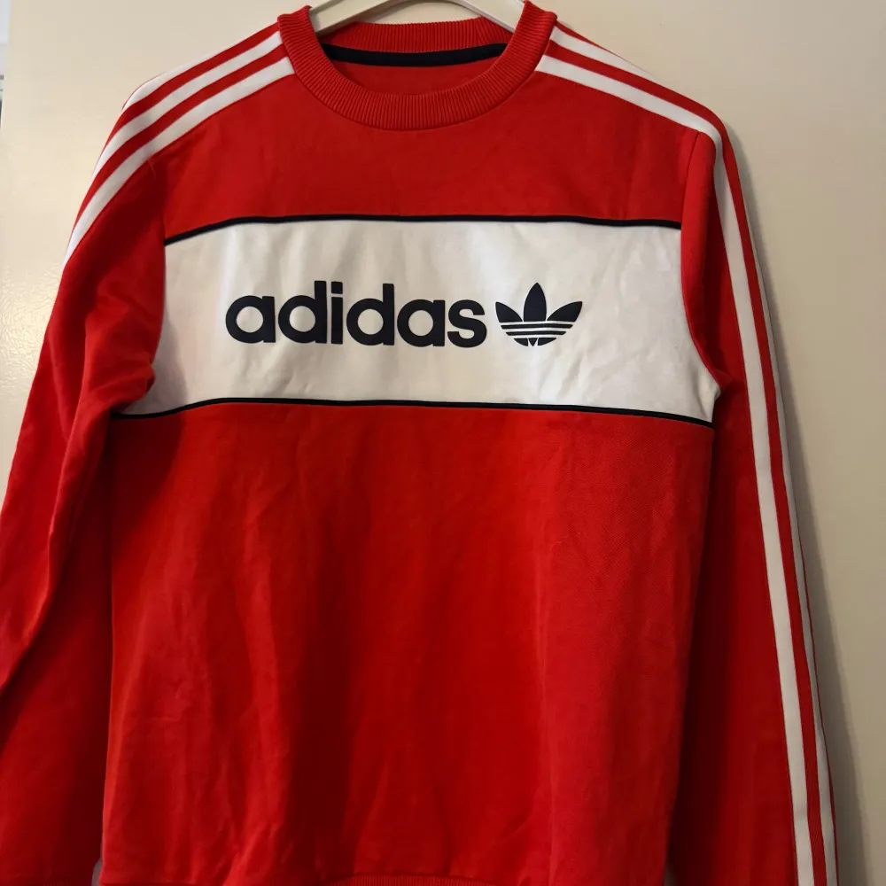 En röd Adidas tröja som inte använts på länge, är i storlek S men passar M . Tröjor & Koftor.