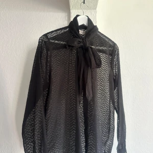 Svart prickig genomskinlig blus - En fin blus i svart som är lite prickig, den kommer från SOKED in luxury och är i storlek S. 