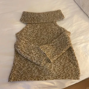 Beige stickad polotröja från Michael Kors - Säljer en supermysig beige stickad polotröja från Michael Kors. Perfekt för kyliga dagar med sin tjocka krage och långa ärmar. Tröjan har en härlig melerad look med inslag av vitt och brunt. Passar perfekt till både jeans och kjol för en avslappnad men stilren look. 🧶✨