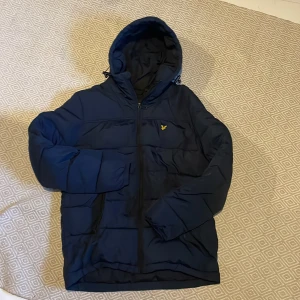 Vinter jacka - Säljer en mörkblå vinter jacka från lyle & slott som är perfekt till kallare väder, jackan är i nyskick förutom att den är lite sliten på dragkedjan se bild 4!