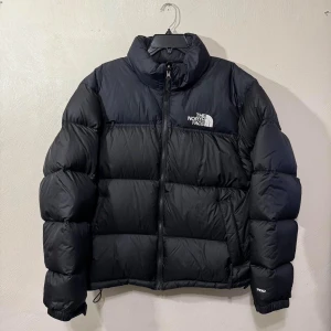 The North Face 1996 Retro Nuptse  - The North Face Nuptse jacka  Skick: som ny, knappt använt  Färg: Svart Storlek: L Pris: 2600kr (köpt för 3800kr)  Säljer den eftersom den inte passar min stil. Skön och mysig, perfekt inför vintern :). 
