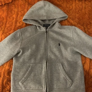 Grå hoodie från Polo Ralph Lauren - Säljer en snygg och bekväm grå hoodie från Polo Ralph Lauren. Köpt för 1 250 och knappt använd. Perfekt för en avslappnad stil och passar till alla tillfällen. Den är i bra skick och supermjuk!