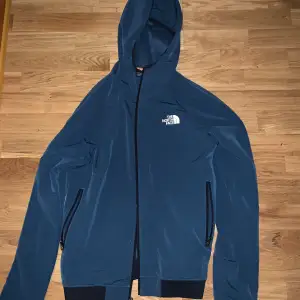 Säljer en snygg blå jacka från The North Face. Den är perfekt för både höst och vinter. Jackan är i nyskick och har en smal passform. Perfekt för dig som vill ha en stilren och funktionell jacka! Priset kan diskuteras!