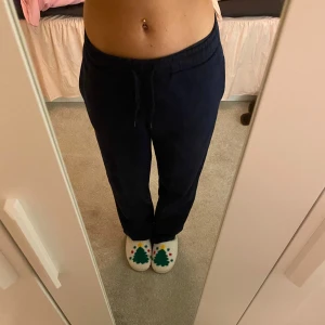 Mörkblå mjukisbyxor - Säljer ett par mörkblå mjukisbyxor i bra skick. De har en bekväm passform med resår och snörning i midjan. Perfekta för mysiga dagar hemma eller en avslappnad dag ute. Storleken är dam M.