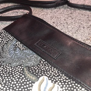 Blommig axelväska från Ceannis - Säljer en superfin axelväska från Ceannis med ett blommigt mönster i dova färger. Väskan har en svart rem och detaljer i skinn. Perfekt för både vardag och fest! 🌸