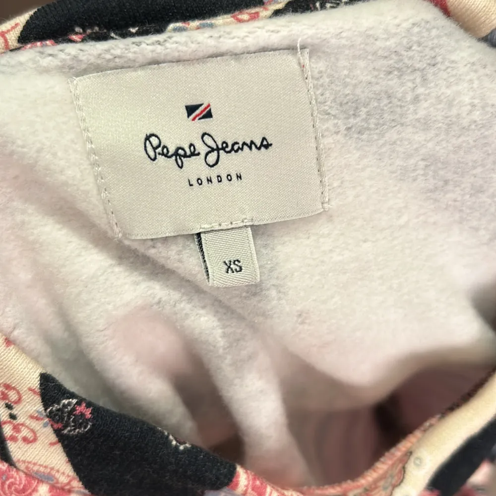 Säljer en supercool mönstrad tröja från Pepe Jeans i storlek XS. Tröjan har ett unikt geometriskt mönster i rosa, blått, svart och beige. Den är långärmad och perfekt för att liva upp din garderob. Passar både till vardags och festliga tillfällen! Den är helt oanvänd och mjuk inuti, en perfekt present till din mamma! Skriv till mig om du vill bestämma ett nytt pris!. Tröjor & Koftor.