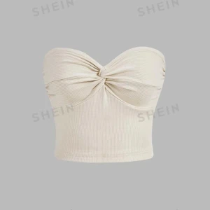 Beige ribbad tubtopp  - Snygg beige tubtopp i ribbat material. Toppen har en twistdetalj framtill som ger en cool look. Perfekt för sommardagar eller en utekväll. Den är axelbandslös och croppad, vilket gör den både trendig och bekväm.