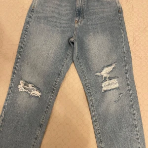 Ljusa jeans med slitningar - Säljer ett par ljusa jeans från Gina tricot i storlek 38. De är i bra skick och är oanvända har en fin design på framsidan.