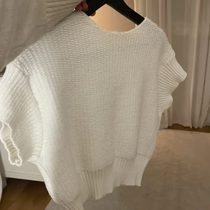Vit stickad tröja - Superfin vit stickad tröja i mycket bra skick. Den har en loose passform och korta ärmar, perfekt för lager på lager-stil. Ribbad nederkant ger en snygg detalj. 