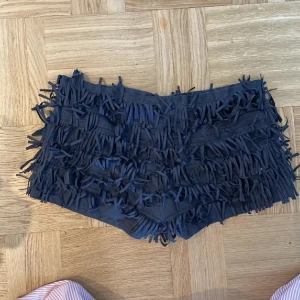 Svarta shorts med fransar - Säljer ett par coola svarta lågmidjade shorts med fransar.