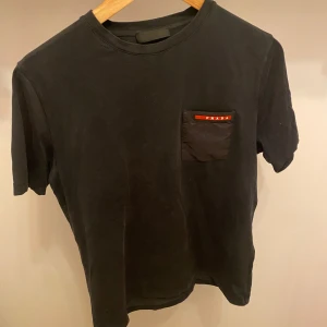 Prada T-Shirt - Hej! Säljer nu min t-shirt från märket  Prada , storlek S, mycket bra skick, tveka inte på att höra av dig om du har frågor eller funderingar kring skorna!