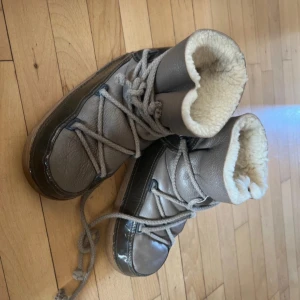 Beiga vinterboots med foder - Säljer mina mysiga beiga IKKII vinterskor med snörning och varmt foder. Perfekta för kalla vinterdagar! De har en snygg glansig yta och en robust sula som ger bra grepp. Använda 3-4 gånger. Nypris: runt 3000kr. Inga skador eller difekter. Pris kan diskuteras!💕