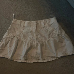 Vit kjol från Angel Eyes - Säljer en söt vit kjol från Angel Eyes i storlek 38. Kjolen har en volangdetalj. Den är i bra skick och har en knapp framtill. Passar både till vardags och festligare tillfällen.