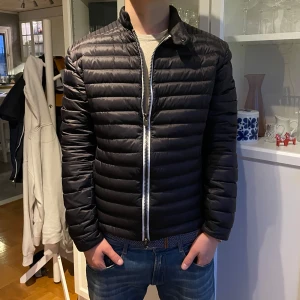 Svart quiltad jacka från Colmar - Säljer en snygg svart quiltad jacka från Colmar i mycket bra skick! Den är perfekt för hösten och våren, funkar även för vinter då jag haft den under vintern. Jackan är långärmad och har en normal passform. Insidan är fodrad för extra värme. Perfekt för dig som vill ha en stilren look! Den är i storlek 50/M. Hör av er vid eventuella frågor. Kan gå ner i pris vid snabb och smidig affär:))) 