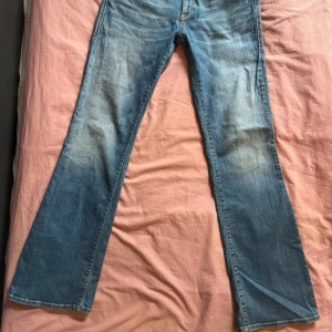 Blå bootcut och lågmidjade jeans från Mavi - Säljer ett par snygga blå bootcut jeans från Mavi Jeans Co. Säljer pga att de är lite för stora. Midja - 40cm innerbenslängd - 80cm         ända täcken på användning syns på bild nr 4     köptes nya för 700kr