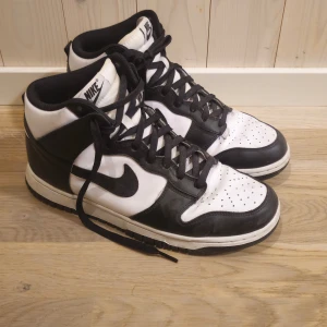 Nike Dunk High Retro Män Stl 43 - Säljer ett par klassiska snygga Nike dunk high retro i svart och vitt. De har en snygg hög modell med snörning och är i bra skick. Perfekta för vardagen. 