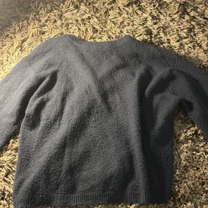Mörkblå stickad tröja - Mysig mörkblå stickad tröja i bra skick. Perfekt för kyliga höst- och vinterdagar. Tröjan har långa ärmar och en enkel design som gör den lätt att matcha med olika outfits. Perfekt för både vardag och avslappnade tillfällen.