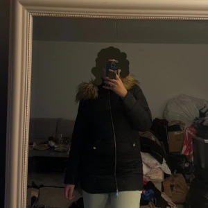 Svart vinterjacka med pälskrage - Säljer en svart vinterjacka med mysig pälskrage. Den är i bra skick och supervarm! Storlek 36/38