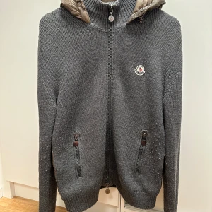 Moncler Cardigan - Den mest eftertraktade och snyggaste Moncler cardiganen på marknaden!| Självfallet äkta, har kvitto och moncler autentication| I nyskick, inga defekter alls och storlek L, men passar lätt mig som är M| Väldigt sought after, finns inte alls många på marknaden då det är en äldre modell som blivit populär nu!| Noppret ni ser kan man lätt ta bort med en liten maskin!| Skriv gärna vid funderingar!⭐️